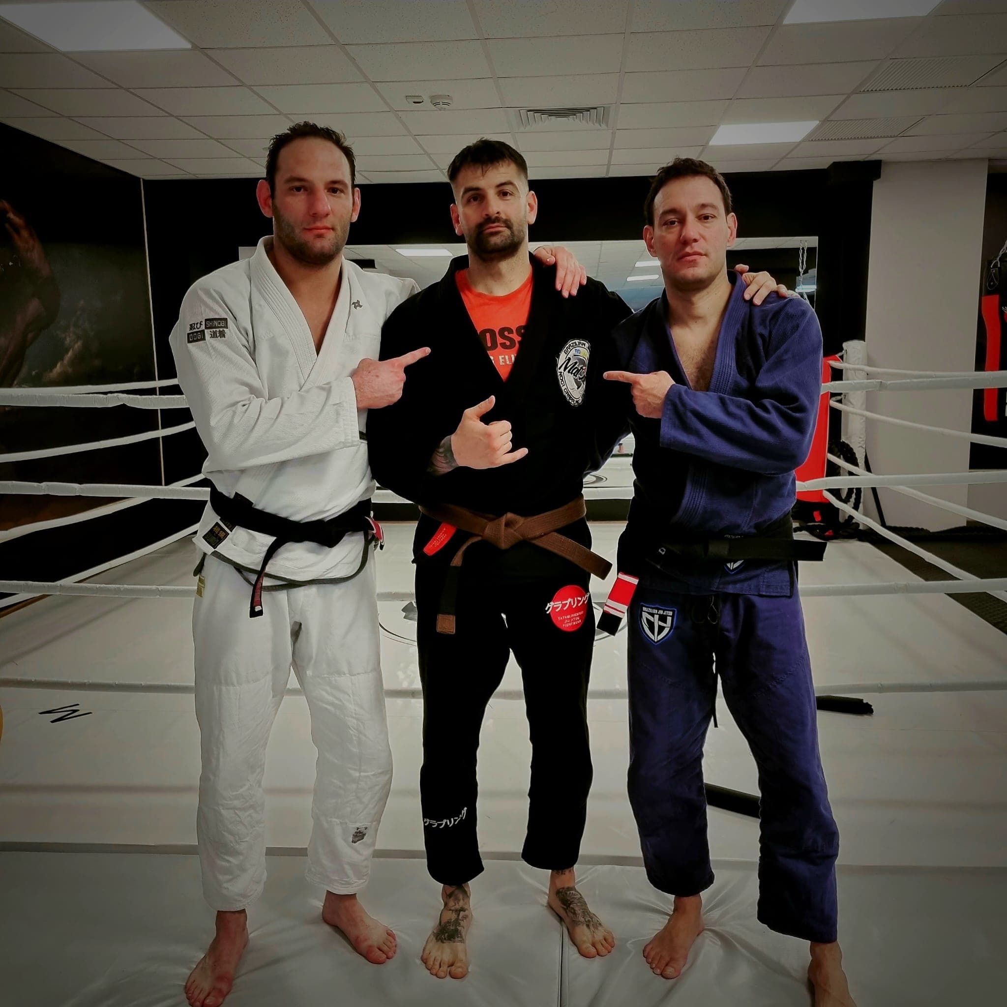 Trei sportivi în kimono, în sala de antrenament