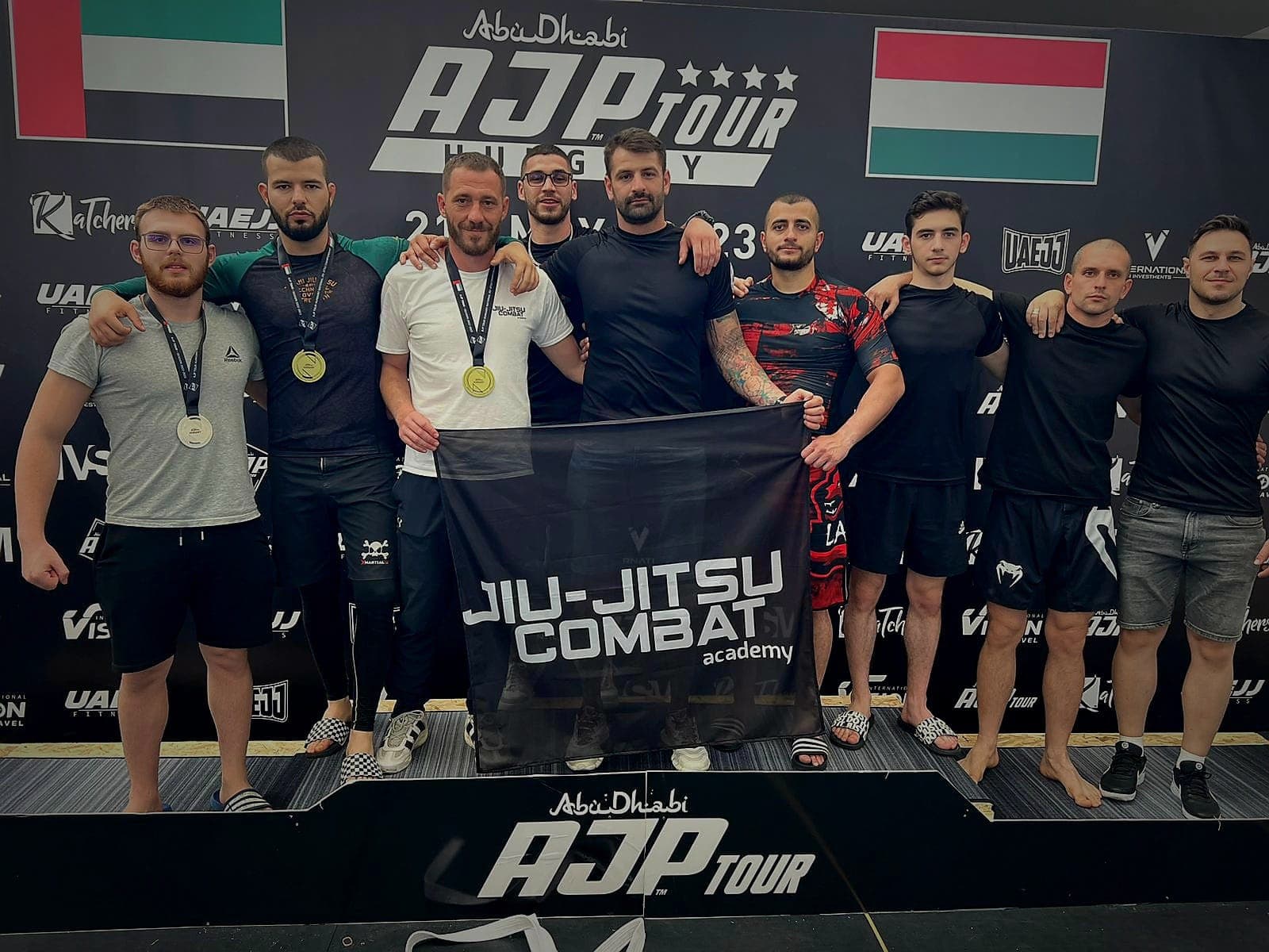Sportivi cu medalii și bannerul clubului, la AJP Tour Ungaria