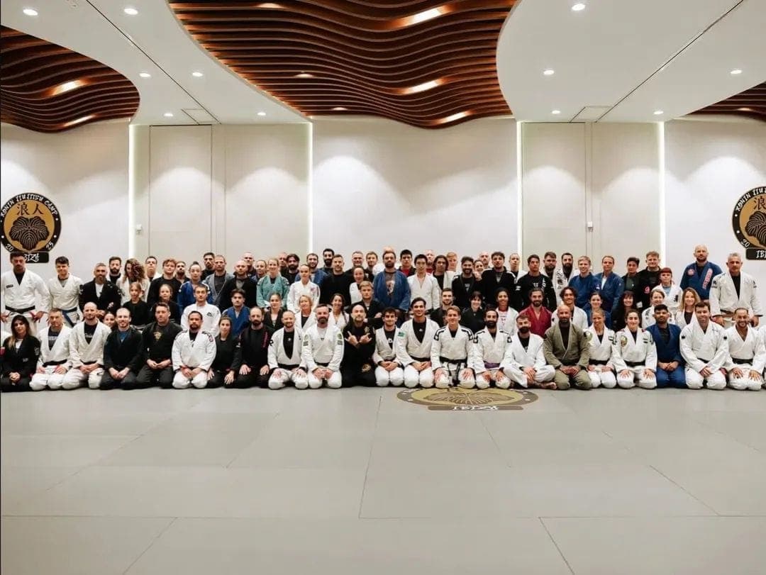 Fotografie de grup într-o sală mare, câteva zeci de practicanți în kimono alb
